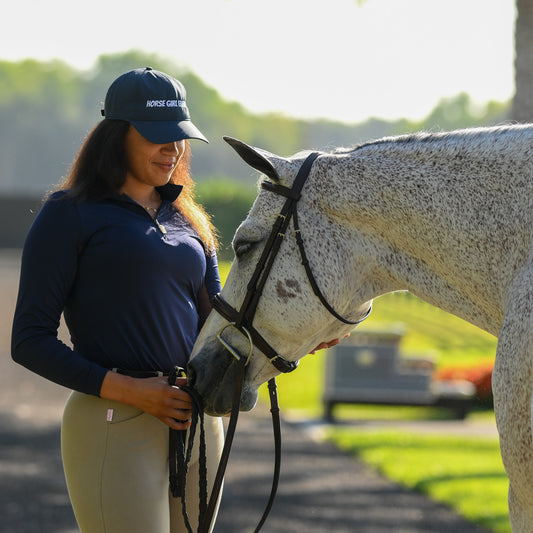Young female equestrian posing with her horse, wearing a stylish Navy Sun Shirt by EA Limited Inc. featuring a quarter-zip design and UPF 50+ protection.