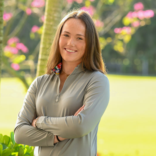 Young woman confidently posing in gray International Sun Shirt by EA Limited Inc., featuring a quarter zip, UPF 50+ protection, and international flags printed on the inside collar.